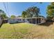 Spacious backyard featuring a screened patio and mature trees at 2285 Victory Ave, Largo, FL 33770