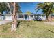 Quaint single-story home with a well-manicured lawn and mature trees at 2285 Victory Ave, Largo, FL 33770