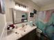 Bathroom showcasing a vanity with sink and decorative lighting, along with a toilet and shower with a matching shower curtain at 2434 Australia E Way # 50, Clearwater, FL 33763