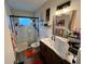Bright bathroom featuring a glass-enclosed shower, white tile, wood vanity, and modern black fixtures at 2434 Australia E Way # 50, Clearwater, FL 33763