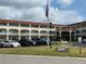 A sunny exterior view of the building with a flag in the front and multiple cars parked outside at 2434 Australia E Way # 50, Clearwater, FL 33763