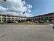 Wide angle shot of multi-unit residential building featuring a parking area and landscaped lawn at 2434 Australia E Way # 50, Clearwater, FL 33763