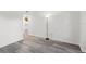 Bright bedroom with gray wood-look flooring and view into hallway and kitchen at 2500 Winding Creek Blvd # A104, Clearwater, FL 33761