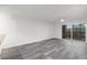 Bright living room with gray wood-look flooring and sliding glass doors to outdoor patio at 2500 Winding Creek Blvd # A104, Clearwater, FL 33761