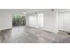Spacious living room features neutral walls, gray wood flooring and sliding glass doors at 2500 Winding Creek Blvd # A104, Clearwater, FL 33761