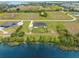 Aerial view of a single-Gathering home highlighting its backyard and proximity to a lake at 3070 Smilodon Trl, Ruskin, FL 33570