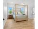 Bright bedroom with a canopy bed and two large windows at 3070 Smilodon Trl, Ruskin, FL 33570