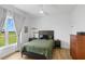 Calm bedroom featuring a large window and a neatly made bed with black accents at 3070 Smilodon Trl, Ruskin, FL 33570