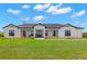 Charming exterior showcasing the home's manicured lawn and inviting front porch seating at 3070 Smilodon Trl, Ruskin, FL 33570