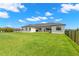 Back exterior of a modern home with a large, manicured backyard at 3070 Smilodon Trl, Ruskin, FL 33570