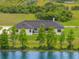 Aerial view of a modern home with a pond in the background at 3070 Smilodon Trl, Ruskin, FL 33570
