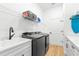 Laundry room equipped with a sink, washer, dryer, storage shelves, and cabinets at 3070 Smilodon Trl, Ruskin, FL 33570