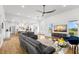 Open-concept living room featuring modern furniture, large windows, and seamless flow to the kitchen at 3070 Smilodon Trl, Ruskin, FL 33570