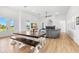Open-concept living and dining area with wood floors and modern furnishings at 3070 Smilodon Trl, Ruskin, FL 33570