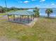 Outdoor picnic area featuring a covered pavilion with picnic tables and a grill, overlooking the waterfront at 3070 Smilodon Trl, Ruskin, FL 33570