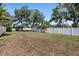 Large backyard with a white fence, large trees, and blooming bougainvillea at 3110 W Ballast Point Blvd, Tampa, FL 33611