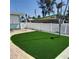 Backyard with a white picket fence and lush, green synthetic grass at 319 Boca Ciega Dr, Madeira Beach, FL 33708
