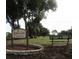 Highland Lakes Golf Club sign sits on the course with golf course and bench in view at 3283 Hilary Cir # 2C, Palm Harbor, FL 34684