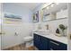 Stylish bathroom featuring blue vanity with white vessel sink and gold fixtures, complemented by wainscoting at 3317 W Iowa Ave, Tampa, FL 33611