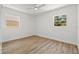 Comfortable bedroom with wood-look flooring, ceiling fan, and two windows offering natural light at 3317 W Iowa Ave, Tampa, FL 33611