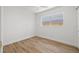 Minimalist bedroom featuring wood-look floors, fresh paint, and a large window providing ample sunlight at 3317 W Iowa Ave, Tampa, FL 33611