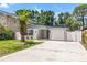 Beautiful single-story home with a well-manicured lawn, beautiful palm tree, and an attached garage at 3317 W Iowa Ave, Tampa, FL 33611