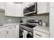 Modern kitchen featuring stainless steel appliances, quartz countertops, and stylish backsplash at 3317 W Iowa Ave, Tampa, FL 33611
