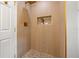 Modern shower with wood-look tile, gold accents, and built-in niche, creating a spa-like experience at 3317 W Iowa Ave, Tampa, FL 33611