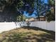 Spacious backyard featuring a pristine white fence and lush greenery, providing a private outdoor space at 3403 Jamais Wood Way, Tampa, FL 33618