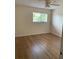 Clean bedroom with wood floors, ceiling fan, natural light from a window, and soft paint at 3403 Jamais Wood Way, Tampa, FL 33618