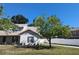 Charming home featuring a white brick facade, mature landscaping, and a well-maintained lawn at 3403 Jamais Wood Way, Tampa, FL 33618