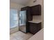 Kitchen features stainless steel refrigerator, dark cabinets and light countertops at 3403 Jamais Wood Way, Tampa, FL 33618