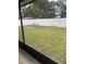 View of the backyard showing the expansive green lawn, white vinyl fencing, and mature trees creating a serene outdoor space at 3505 Gloria Ave, Plant City, FL 33563