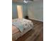 Well-lit bedroom with laminate floors, floral print bedspread, and a door leading to the bathroom at 3505 Gloria Ave, Plant City, FL 33563