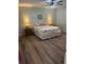 Comfortable bedroom featuring wood laminate floors and a stylish ceiling fan with a lamp at 3505 Gloria Ave, Plant City, FL 33563