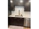 Close-up of kitchen sink and stainless steel appliances with a geometric tile backsplash and wood-look flooring at 3505 Gloria Ave, Plant City, FL 33563
