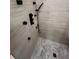Luxurious walk-in shower featuring light tile walls, gray hexagon floor and modern black fixtures at 3505 Gloria Ave, Plant City, FL 33563