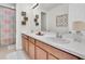 Bright bathroom featuring double sinks, vanity, large mirror, and decorative wall accents at 3850 Bonfire Dr, Odessa, FL 33556