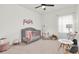 Bedroom featuring a gray crib, comfortable chair, and playful decor at 3850 Bonfire Dr, Odessa, FL 33556