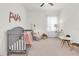 Bedroom featuring a gray crib, comfortable chair, and playful decor at 3850 Bonfire Dr, Odessa, FL 33556