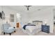 Cozy bedroom featuring a bed with white bedding, a blue throw, and a striped accent chair at 3850 Bonfire Dr, Odessa, FL 33556