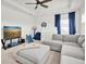 Bonus room featuring a ceiling fan, television, large sofa, and a play area for  at 3850 Bonfire Dr, Odessa, FL 33556