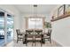 Bright dining room with designer lighting, seating for six, and sliding glass doors to the pool area at 3850 Bonfire Dr, Odessa, FL 33556
