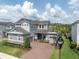 Stunning two-story home showcases meticulous landscaping, a paved driveway, and a three-car garage at 3850 Bonfire Dr, Odessa, FL 33556