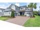 Beautiful two-story home with a three-car garage, paved driveway, and lush landscaping at 3850 Bonfire Dr, Odessa, FL 33556