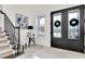 Welcoming foyer with a staircase, elegant decor, and stylish black double doors at 3850 Bonfire Dr, Odessa, FL 33556