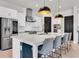 Bright, modern kitchen boasts white cabinets, stainless steel appliances, and an expansive island with seating for four at 3850 Bonfire Dr, Odessa, FL 33556