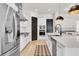Modern kitchen featuring stainless steel appliances, white cabinets, an expansive island, and black interior doors at 3850 Bonfire Dr, Odessa, FL 33556