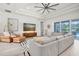 Bright living room with tray ceilings, a modern ceiling fan, and sliding glass doors leading to the screened pool at 3850 Bonfire Dr, Odessa, FL 33556