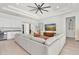 Spacious living room with tray ceilings, a modern ceiling fan, a bar area, and an open concept design at 3850 Bonfire Dr, Odessa, FL 33556